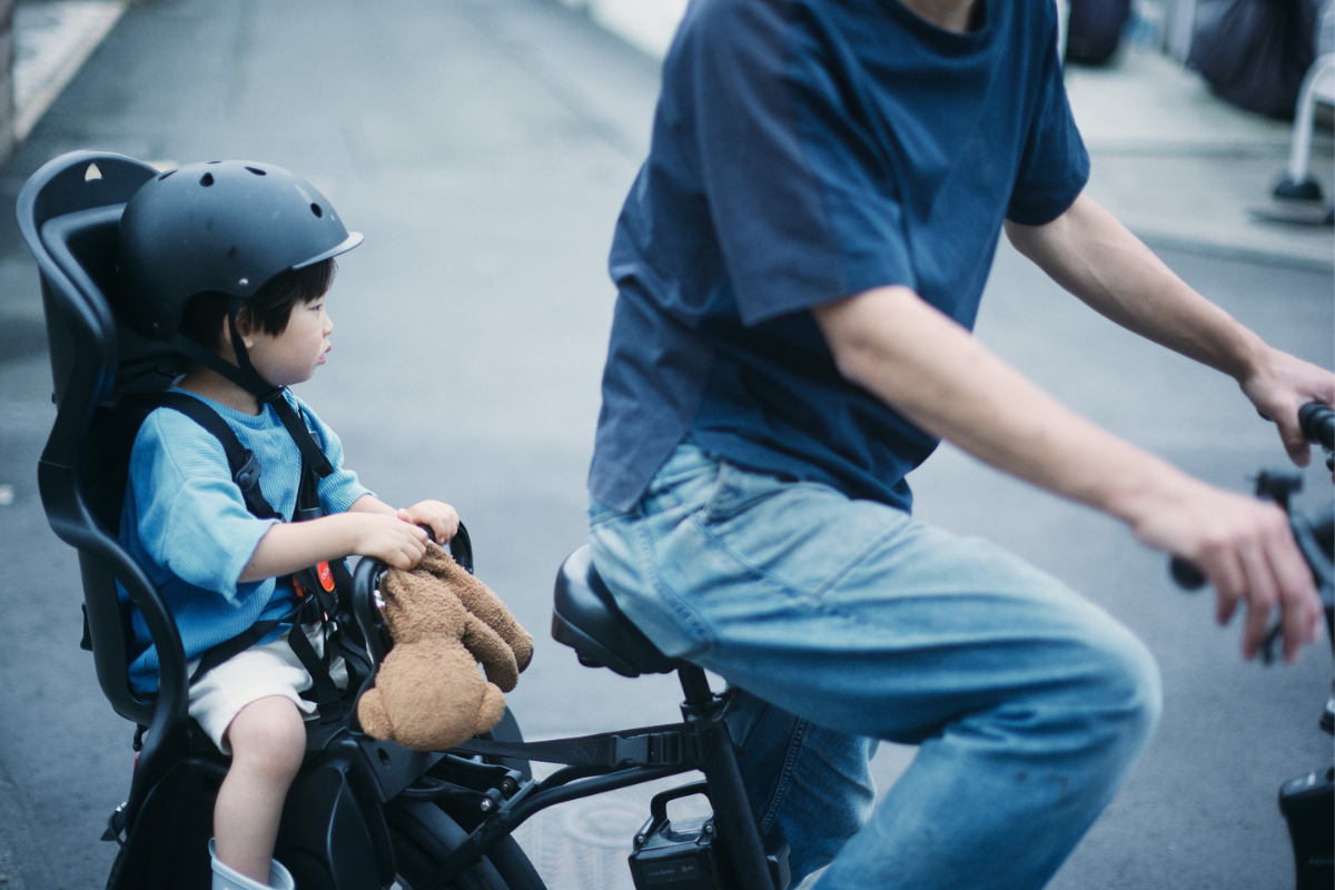 自転車に乗るこどもとそばにいる大人