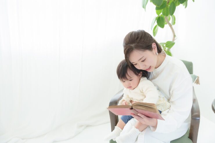 赤ちゃんに絵本を読むお母さん